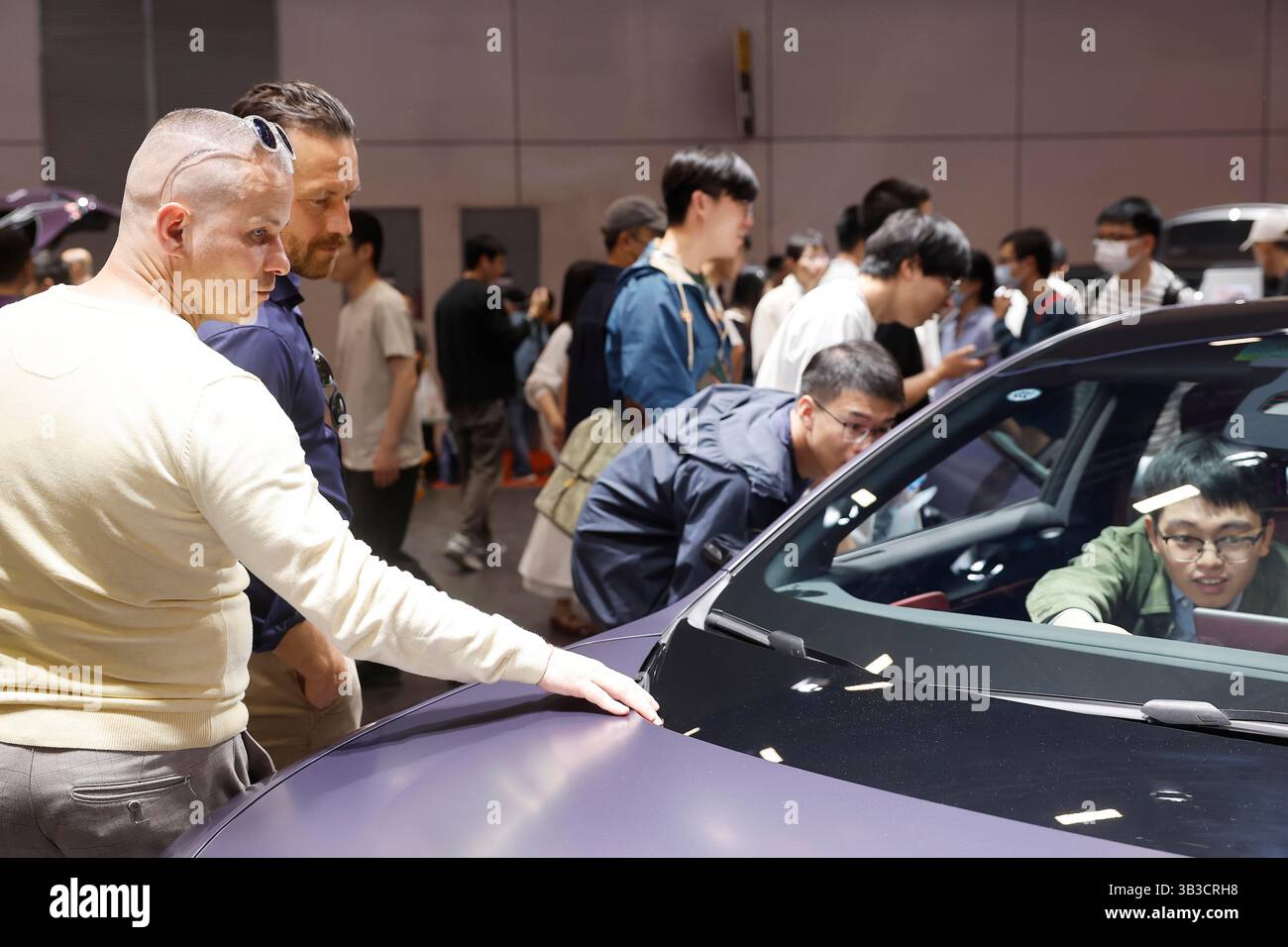 Ausländische Besucher erfahren am Stand von Avatr mehr über das neue Energiefahrzeug. Shanghai, China. 26. April 2025. Ausländische Besucher erfahren auf der 21. Shanghai International Automobile Industry Exhibition (Auto Shanghai) im National Exhibition and Convention Center (Shanghai) am 26. April 2025 mehr über Chinas neue Energiefahrzeuge. Quelle: Yin Liqin/China News Service/Alamy Live News Stockfoto