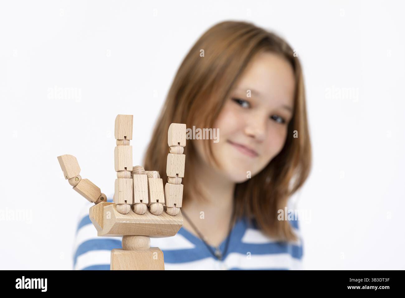 Ein Mädchen posiert spielerisch mit einer Model-Hand-Geste, die ihre lebendige Kreativität und ihren fröhlichen Geist zum Ausdruck bringt Stockfoto