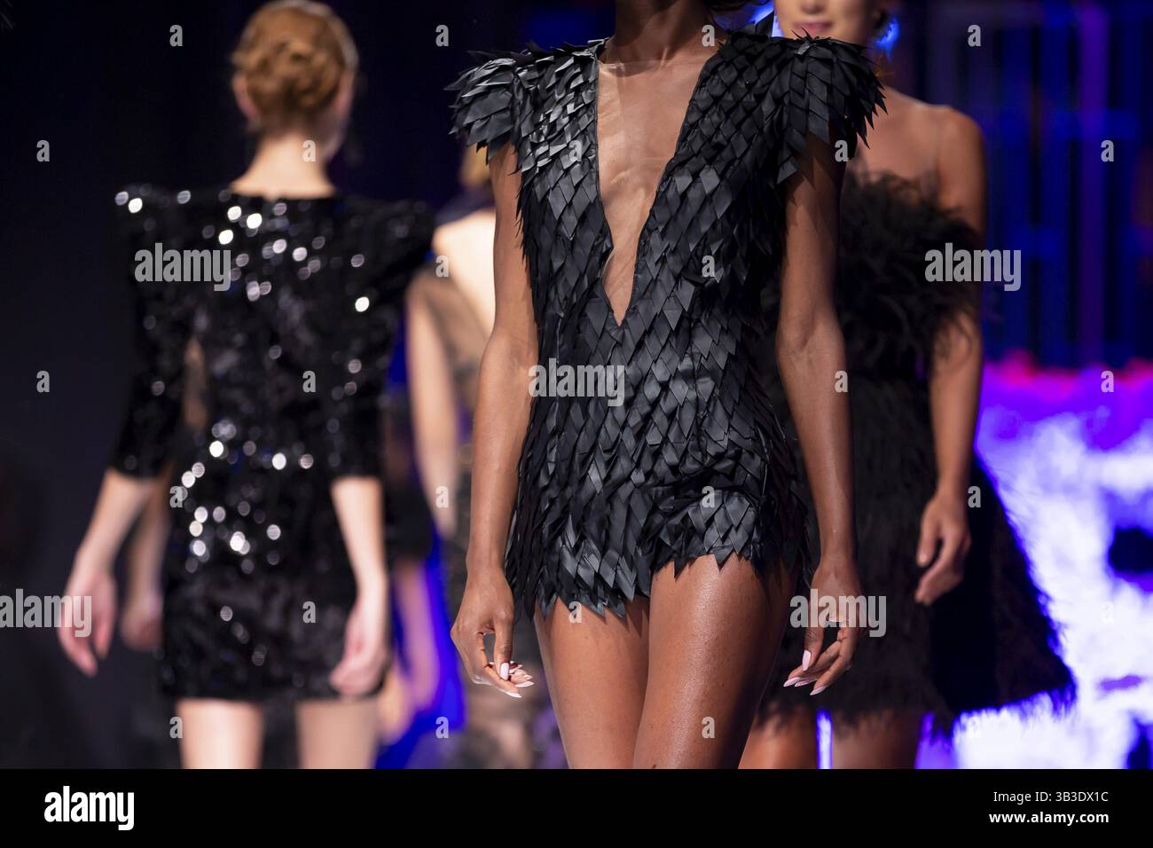 Weibliche Models laufen während einer Fashion Show in verschiedenen schwarzen Kleidern auf dem Laufsteg. Fashion Catwalk Event mit neuer Kollektion von Kleidung Stockfoto