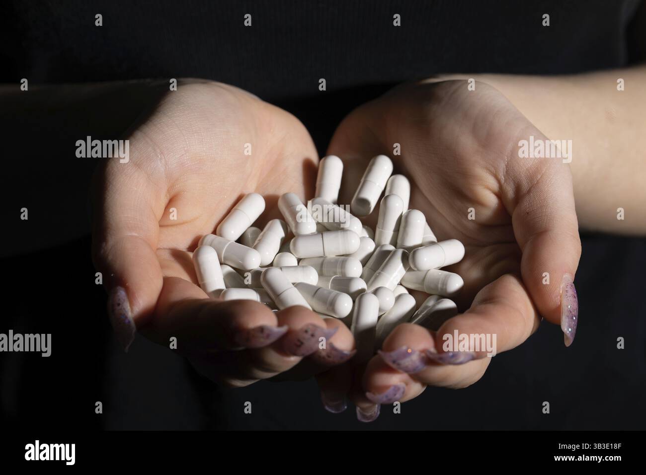 Eine Tablette, die Beschwerden einer schweren Infektionskrankheit behandelt, die auf der Hand einer Frau geben wird Stockfoto