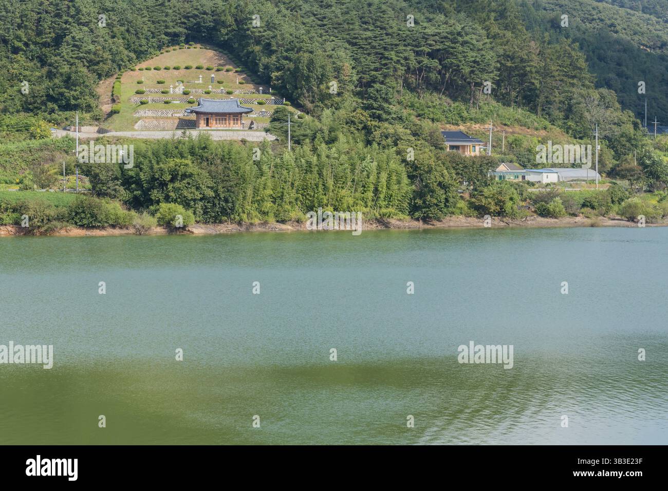 Cheongyang-Gun, Südkorea, 2. Oktober 2020: Kleiner ländlicher Friedhof am Hang mit See im Vordergrund, Asien Stockfoto
