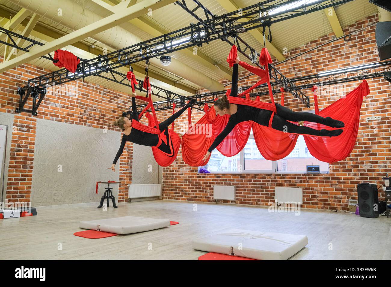 Moskau, Russland, 30.11.2024 Eine Gruppe von Frauen führt Luftakrobatik in einem Fitnessstudio durch. Die Szene ist energiegeladen und aufregend, da die Frauen hier sitzen Stockfoto
