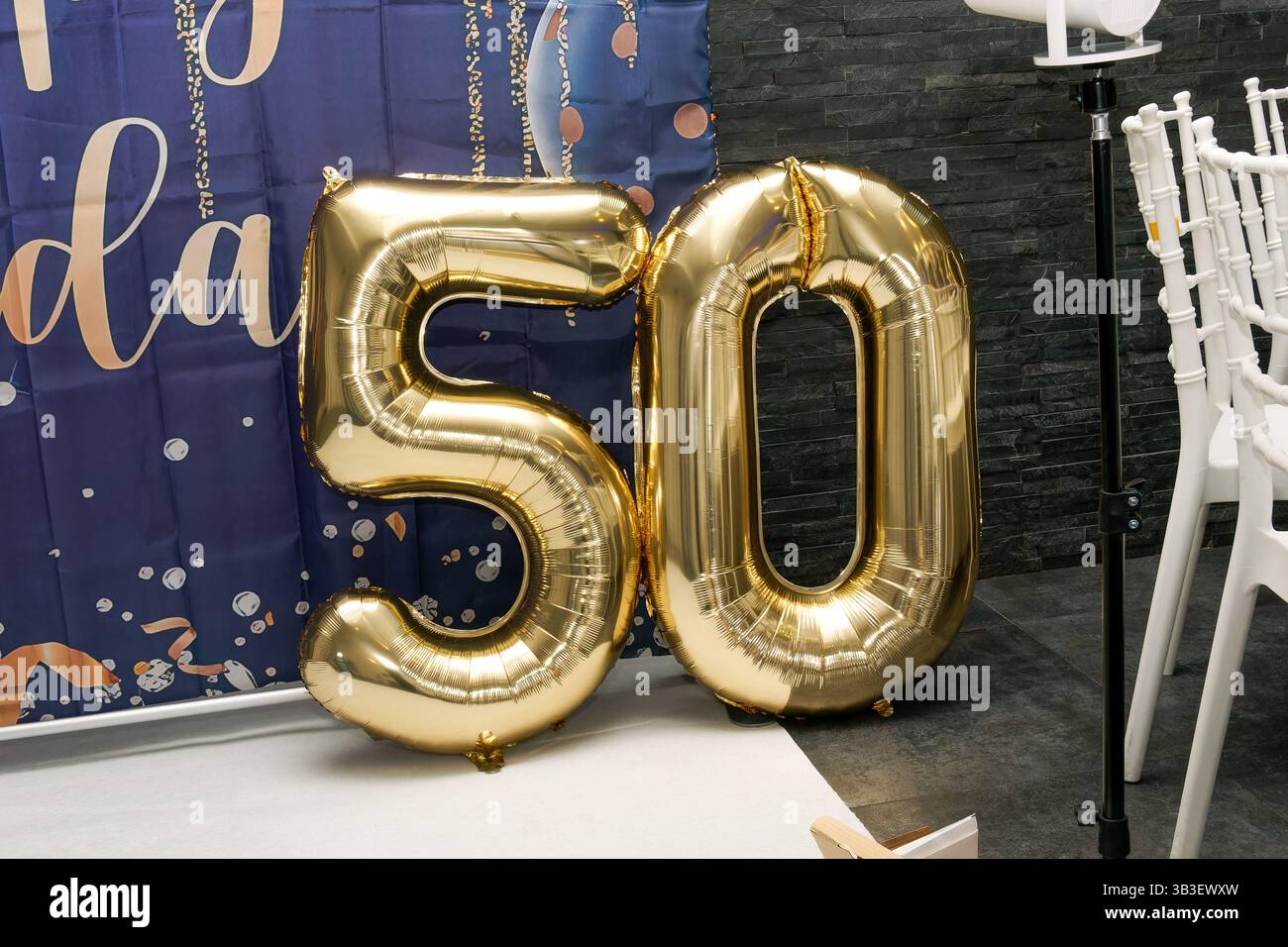 Ballons mit der goldenen Nummer 50 dienen als Dekoration für eine Geburtstagsfeier oder Jubiläumsfeier und symbolisieren einen Meilenstein. Stockfoto