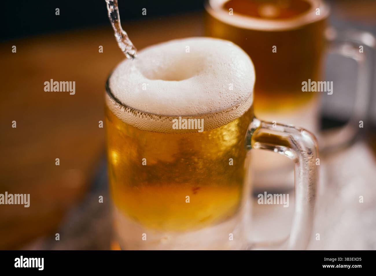 Nahaufnahme einer Tasse Bier auf Holztisch Stockfoto