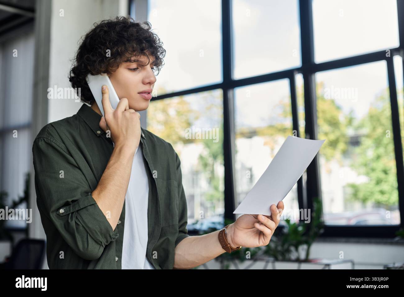 Gesprächspartner mit Papieren und Hingabe in einem modernen Büroumfeld. Stockfoto