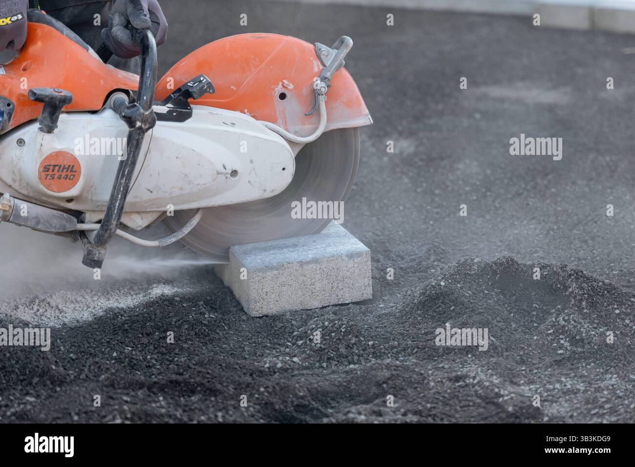 Fachkräftemangel im Baugewerbe harte Arbeit auf der Baustelle 29.04.25, Selters: Symbolfoto, Illustrationsbild, Symbolbild, Illustrationsfoto, Alltagsszene ein Bauarbeiter schneidet mit einer motorbetriebenen Trennscheibe Stihl TS 440 einen Betonstein zu symbolisch für die körperlich anspruchsvolle Arbeit im Baugewerbe. Die Szene steht exemplarisch für die Herausforderungen und den zunehmenden Fachkräftemangel in handwerklichen Berufen. Der Arbeitsplatz ist staubig, die Maschine schwer Arbeitsbedingungen, die immer weniger Menschen auf sich nehmen wollen. . Selters Hessen Deutschland *** Knappheit Stockfoto