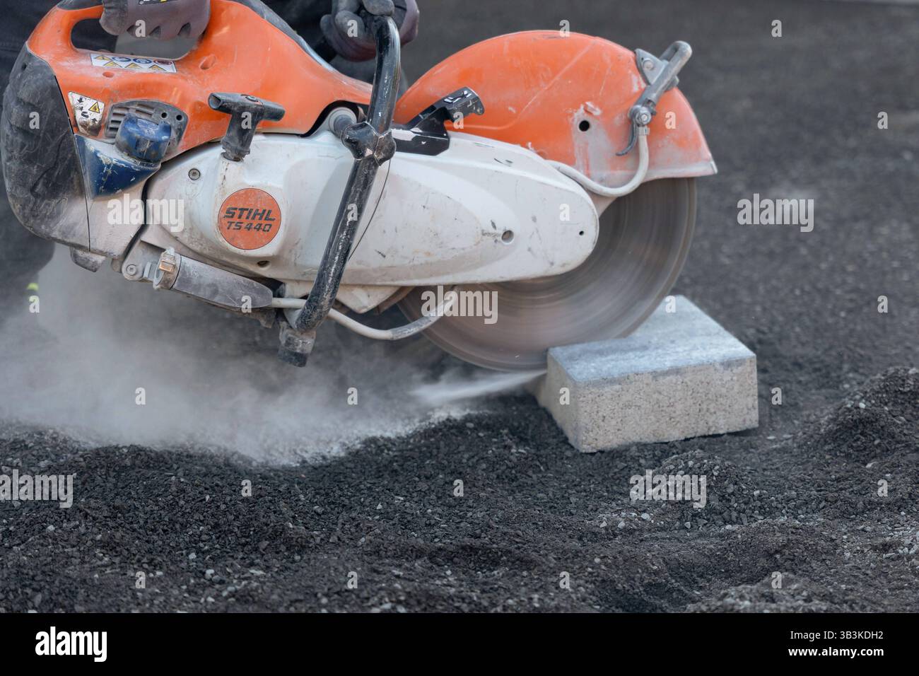 Fachkräftemangel im Baugewerbe harte Arbeit auf der Baustelle 29.04.25, Selters: Symbolfoto, Illustrationsbild, Symbolbild, Illustrationsfoto, Alltagsszene ein Bauarbeiter schneidet mit einer motorbetriebenen Trennscheibe Stihl TS 440 einen Betonstein zu symbolisch für die körperlich anspruchsvolle Arbeit im Baugewerbe. Die Szene steht exemplarisch für die Herausforderungen und den zunehmenden Fachkräftemangel in handwerklichen Berufen. Der Arbeitsplatz ist staubig, die Maschine schwer Arbeitsbedingungen, die immer weniger Menschen auf sich nehmen wollen. . Selters Hessen Deutschland *** Knappheit Stockfoto