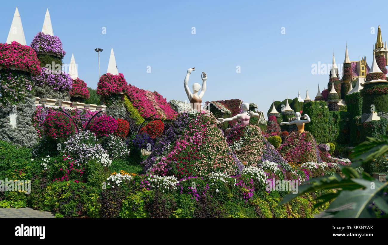 Dubai, VAE - 2. Februar 2023: Figuren von tanzenden Mädchen, dekoriert mit hellen Blumen im größten Blumengarten der Welt, dem Miracle Garden in Stockfoto