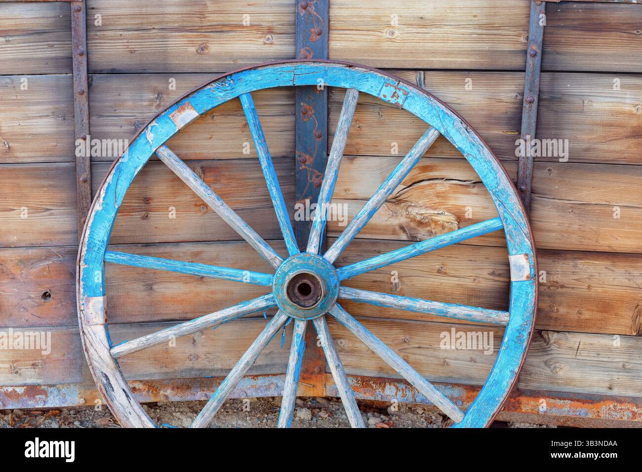 Ein altes Pferdewagenrad vor hölzernem Hintergrund. Nahaufnahme des Vintage-Wagens Stockfoto