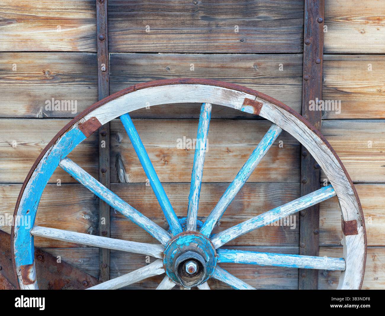 Ein altes Pferdewagenrad vor hölzernem Hintergrund. Nahaufnahme des Vintage-Wagens Stockfoto