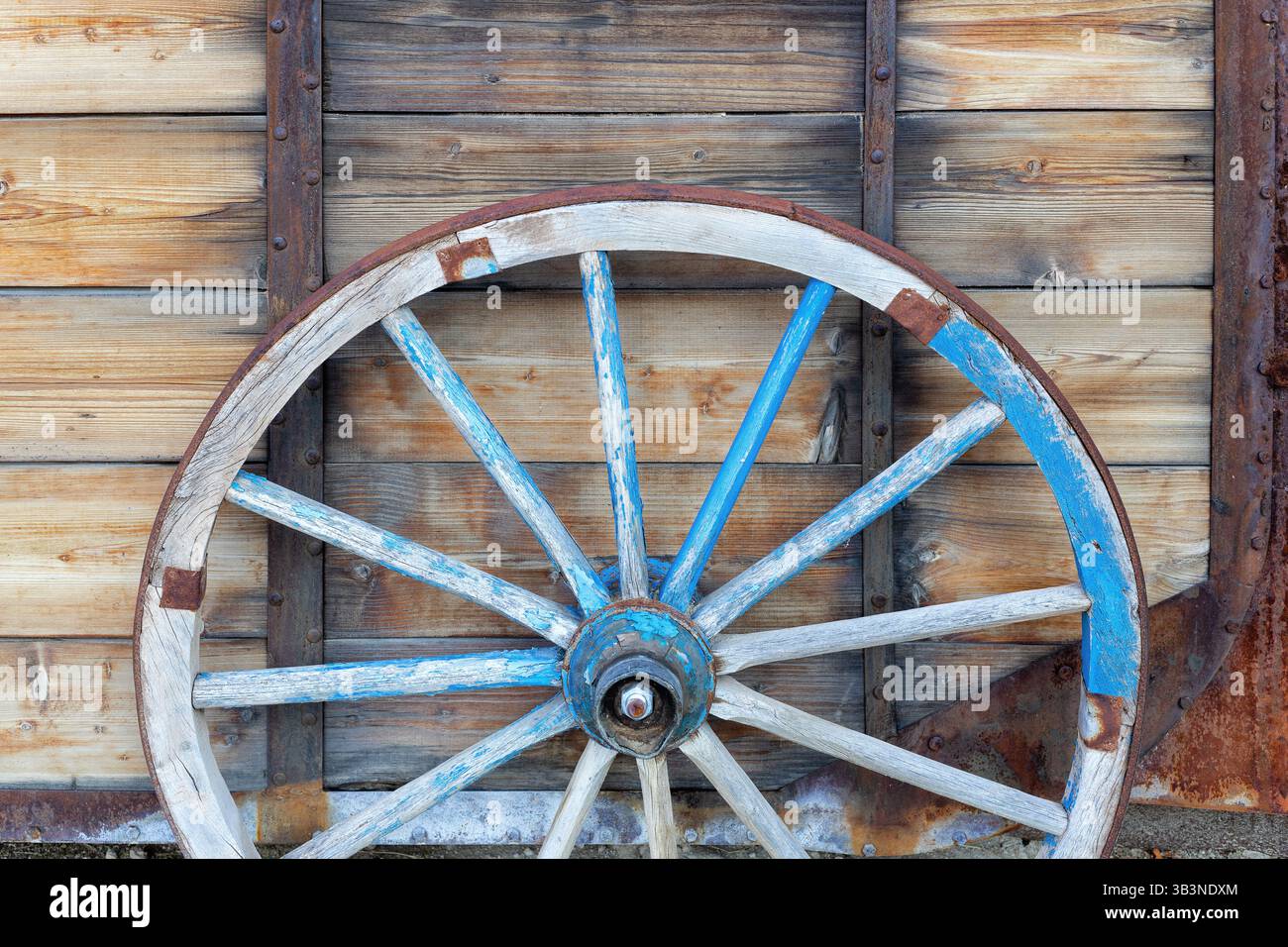 Ein altes Pferdewagenrad vor hölzernem Hintergrund. Nahaufnahme des Vintage-Wagens Stockfoto
