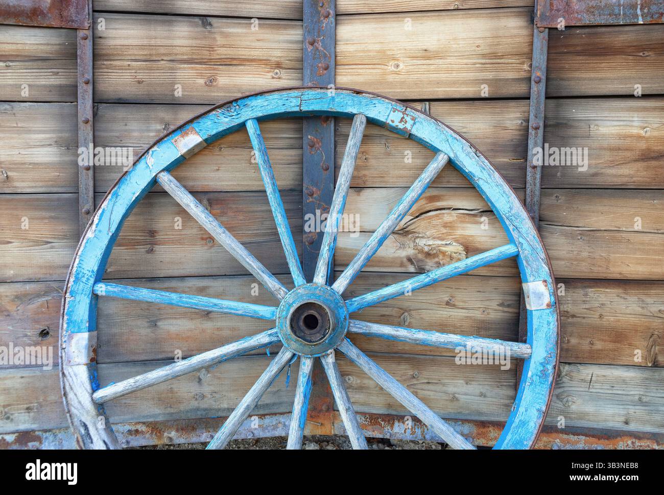 Ein altes Pferdewagenrad vor hölzernem Hintergrund. Nahaufnahme des Vintage-Wagens Stockfoto