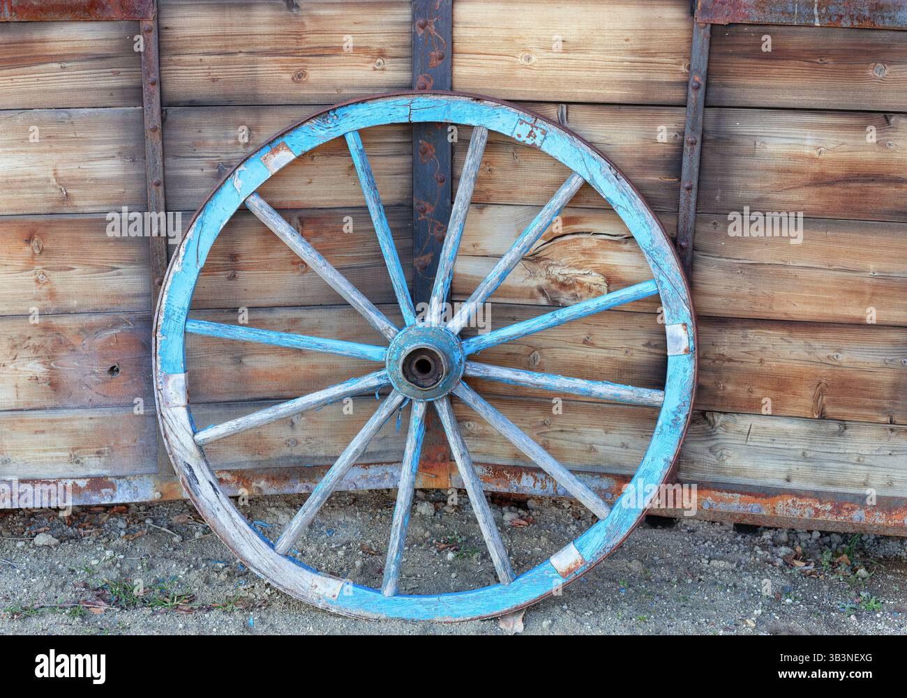 Ein altes Pferdewagenrad vor hölzernem Hintergrund. Nahaufnahme des Vintage-Wagens Stockfoto