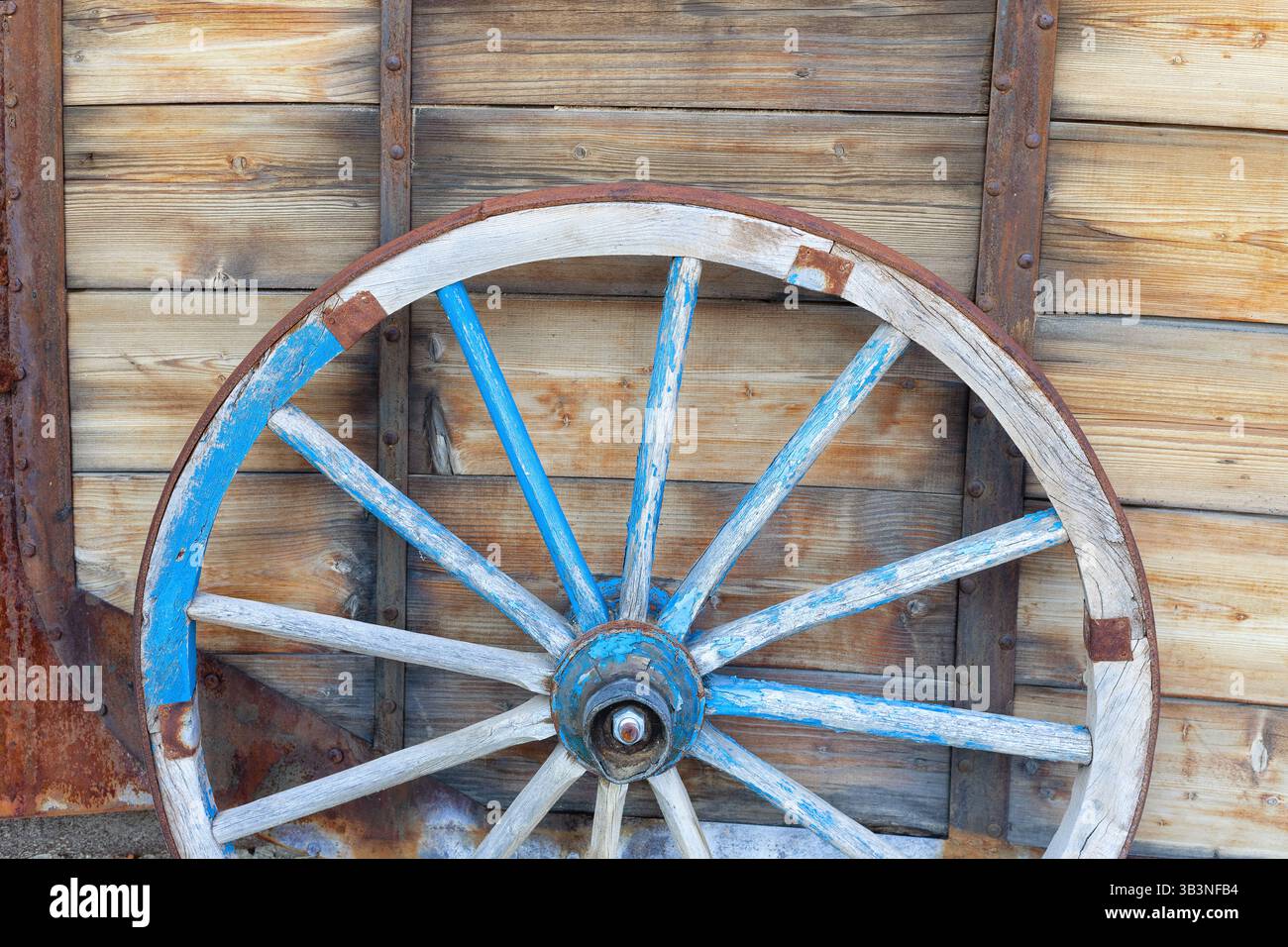 Ein altes Pferdewagenrad vor hölzernem Hintergrund. Nahaufnahme des Vintage-Wagens Stockfoto