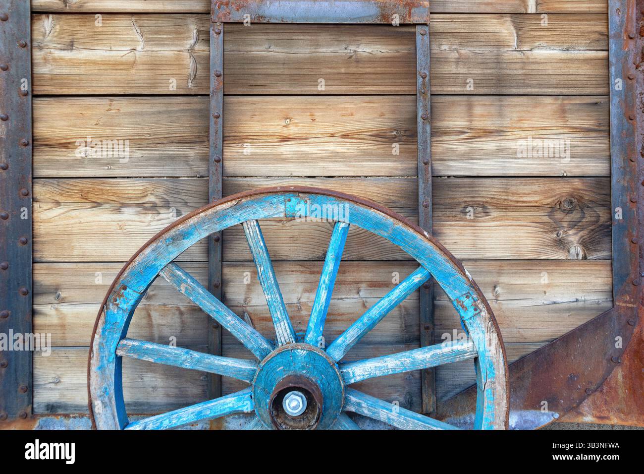 Ein altes Pferdewagenrad vor hölzernem Hintergrund. Nahaufnahme des Vintage-Wagens Stockfoto