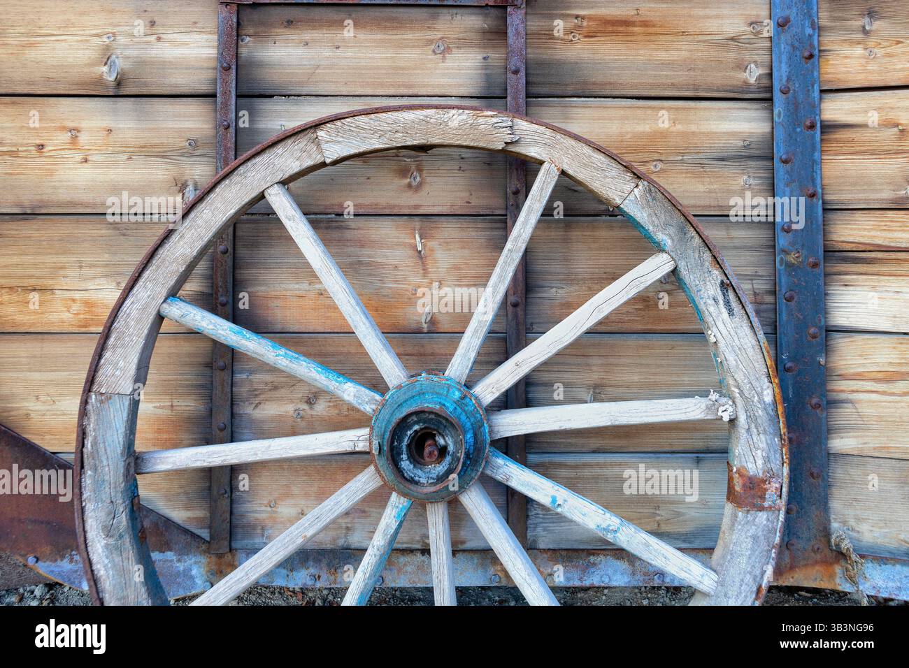 Ein altes Pferdewagenrad vor hölzernem Hintergrund. Nahaufnahme des Vintage-Wagens Stockfoto