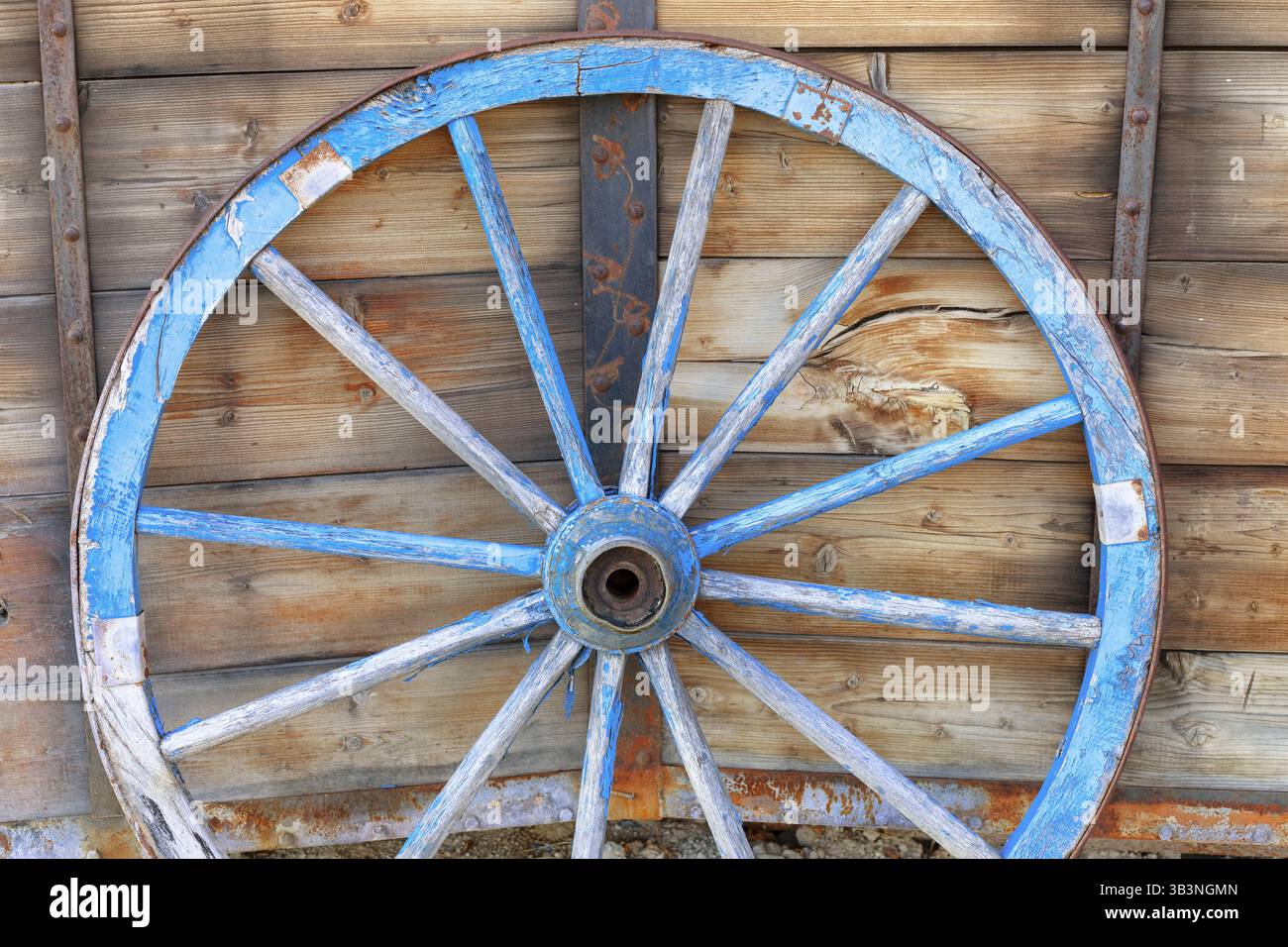 Ein altes Pferdewagenrad vor hölzernem Hintergrund. Nahaufnahme des Vintage-Wagens Stockfoto