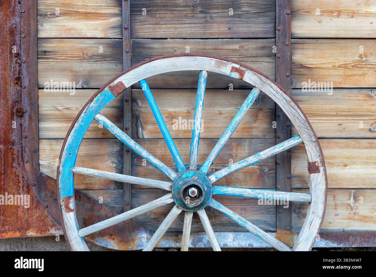 Ein altes Pferdewagenrad vor hölzernem Hintergrund. Nahaufnahme des Vintage-Wagens Stockfoto