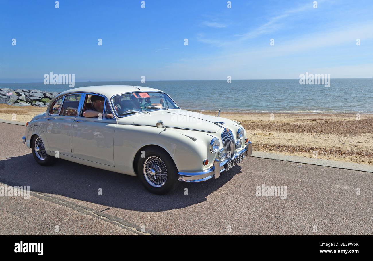 Klassischer weißer Jaguar Mk 2-Wagen an Strandpromenade Strand und Meer im Hintergrund Stockfoto