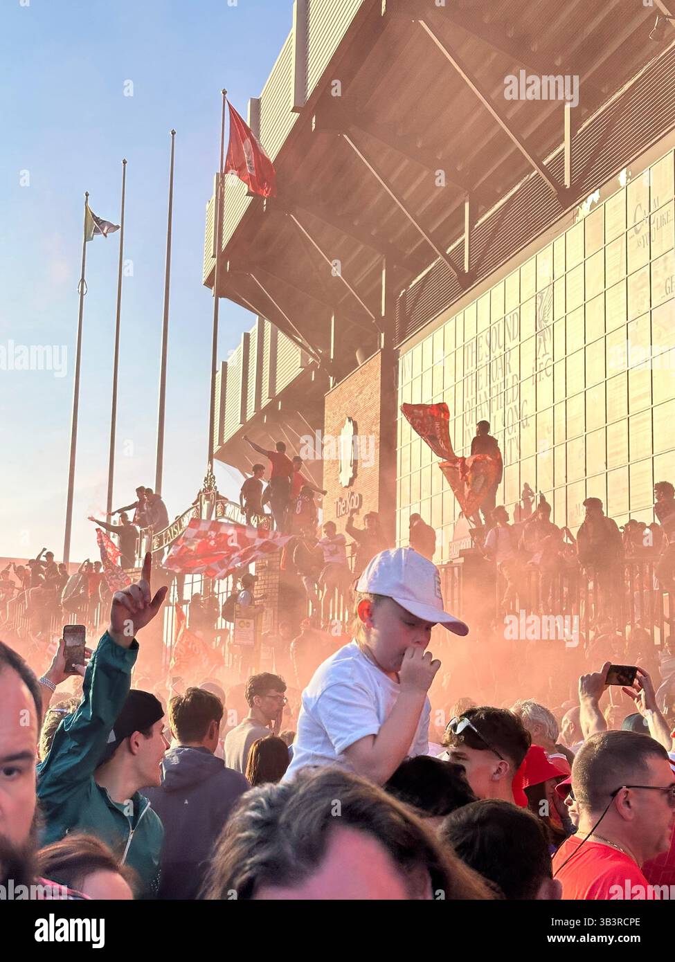 Fans feiern den Sieg in der Premier League in den Straßen vor Anfield mit roten Fahnen, 27. April 2025. - Smartphone-aufgenommenes Stockfoto