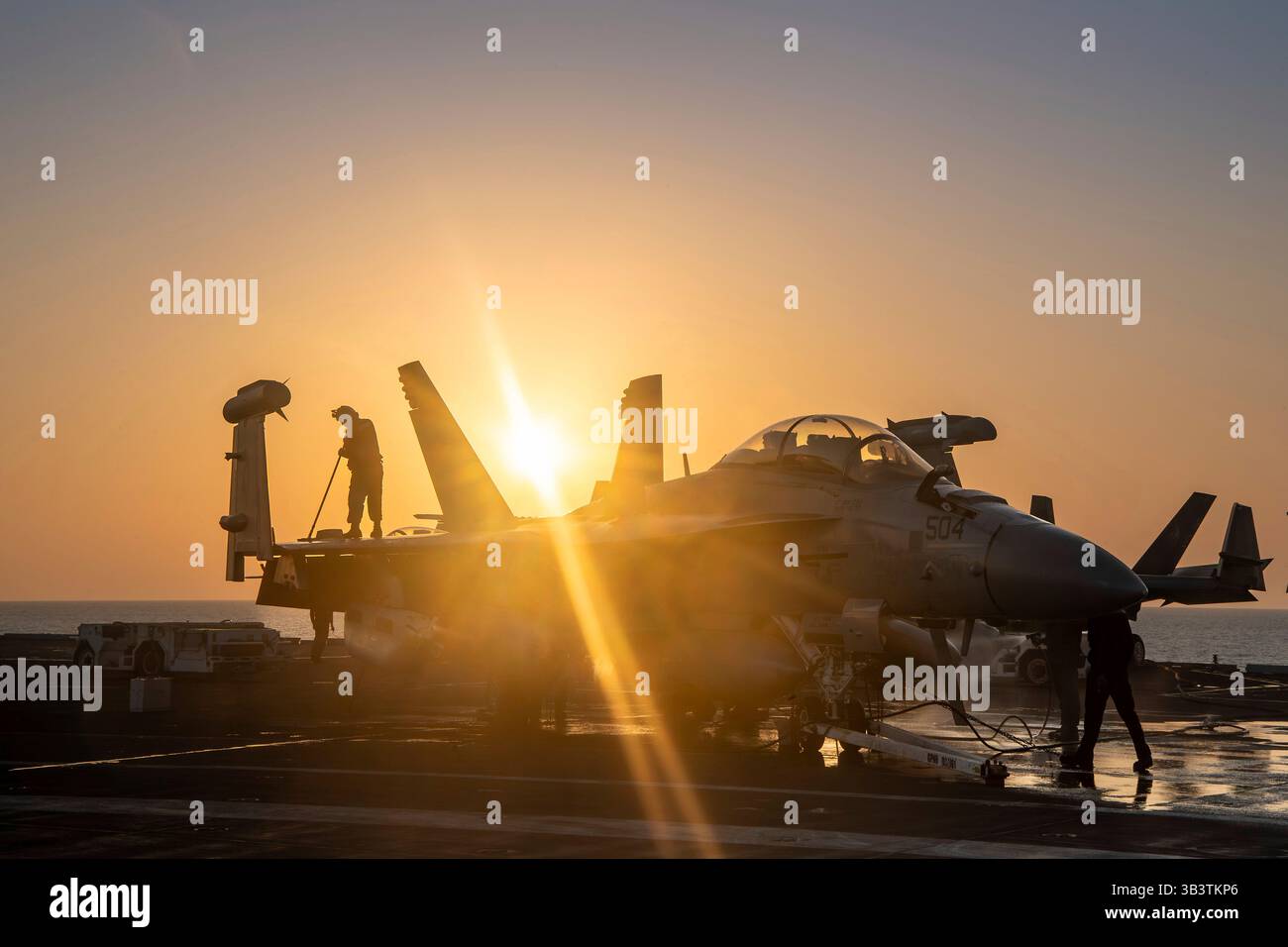Arabisches Meer, Usa. April 2025. Die US-Navy-Seeleute waschen ein EA-18G Growler-Flugzeug mit den Handschuhen der Electronic Attack Squadron 136 auf dem Flugdeck des Flugzeugträgers USS Carl Vinson der Nimitz-Klasse bei Sonnenuntergang während der Operation Prosperity Guardian, 19. April 2025, im Arabischen Meer. Die USS Carl Vinson schloss sich der Operation an, um Houthi-Drohnen- und Raketenangriffe auf die Handelsschifffahrt im Roten Meer zu unterdrücken. Kredit: MC3 Nate Jordan/USA Navy/Alamy Live News Stockfoto