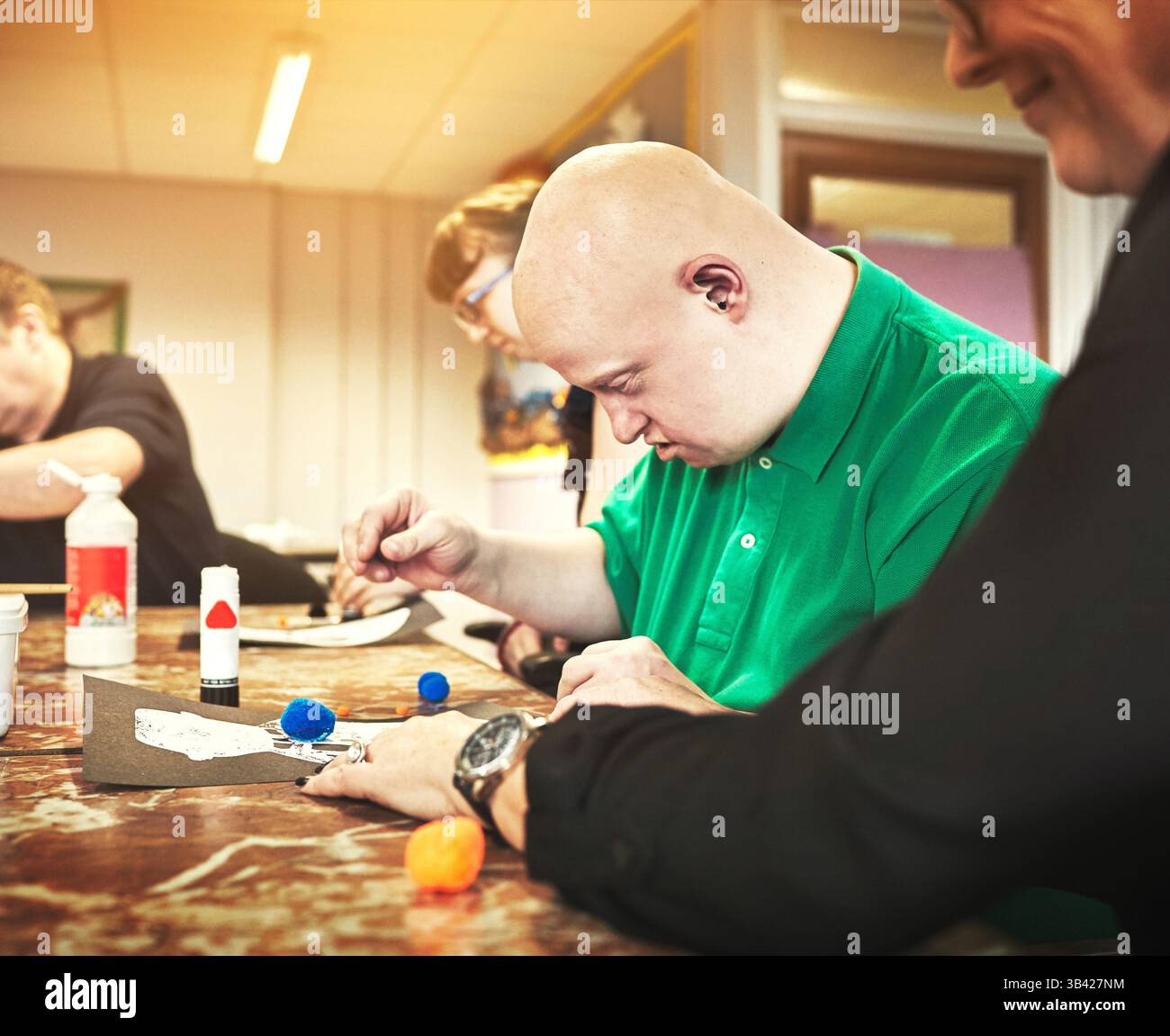 Therapeut hilft Menschen mit Down-Syndrom in der Behindertenbetreuungsgruppe oder in der Kindertagesstätte für Behinderte. Lehre, Spezial und Lernen für Soziales Stockfoto