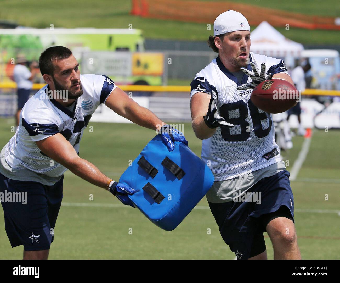31. Juli 2015 – Oxnard, CA, USA – Dallas Cowboys Tight End Geoff Swaim, links, schwingt eine Blockade, während Tight End Ray Hamilton (86) einen Ball während des Morgengangs im Trainingslager Oxnard, Kalifornien, am Freitag, den 31. Juli 2015 beobachtet. (Bild: © Paul Moseley/TNS via ZUMA Wire) Stockfoto