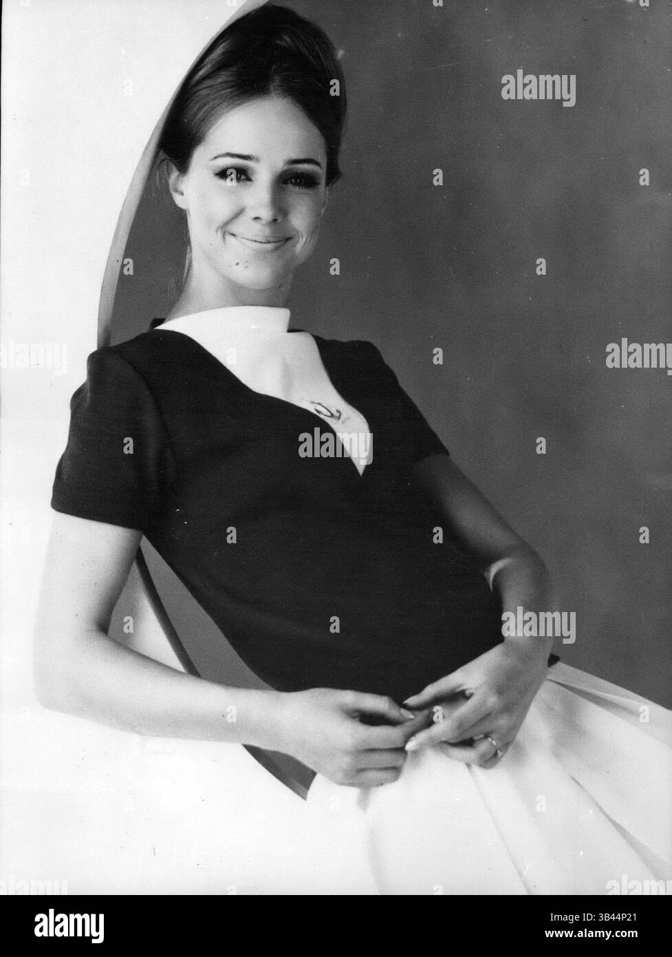 20. Dezember 1962 - der Navy-Look ist noch in der Vogue. Der Navy Look hat immer seine Verteidiger, vor allem in den französischen Resorts, wo viele Frauen Kleidung tragen, die nach Marineuniformen gestaltet wurde. OPS: Dieses schöne Modell präsentiert eine marineblaue Mariniere mit weißem Kragen und weißem Rock, entworfen von Le Marmot Prebac. (Bild: © Keystone Pictures USA/ZUMAPRESS.com) Stockfoto