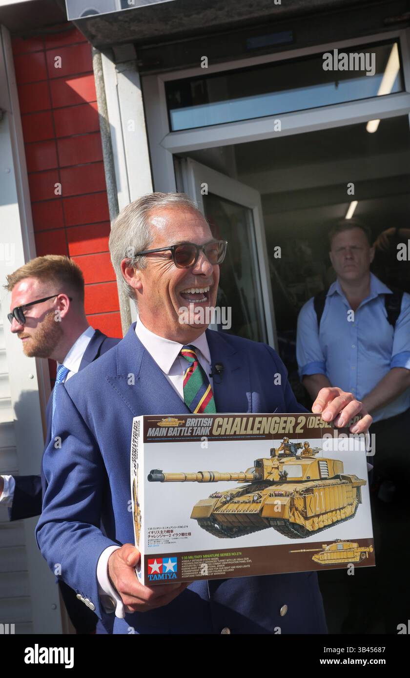 Scunthorpe, Großbritannien. April 2025. Nigel Farage, Parteichef der Reform UK, nimmt ein Modell eines Challenger-Panzers auf, während er in der Ashby High Street zur Unterstützung der britischen Reformkandidatin Dame Andrea Jenkyns auf einem Rundgang geht. Nigel Farage, Anführerin der Reform UK, machte einen Rundgang auf der Ashby High Street in Scunthorpe Borough mit Dame Andrea Jenkyns als Bürgermeisterin von Greater Lincolnshire am 1. Mai. Wenn man glaubt, dass Reform UK etwa 15 Punkte voraus ist. (Foto von Martin Pope/SOPA Images/SIPA USA) Credit: SIPA USA/Alamy Live News Stockfoto