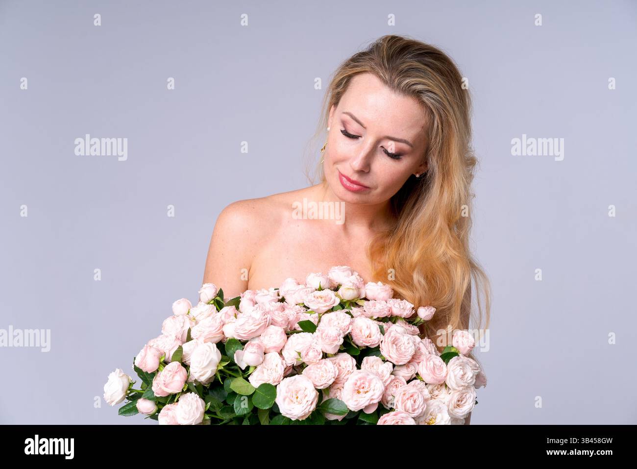 Inspirierende Atmosphäre der Romantik. Schöne Frau mit einem Blumenstrauß im Studio. Geeignet für Werbegeschenke, Blumenwaren, Valentinstag c Stockfoto