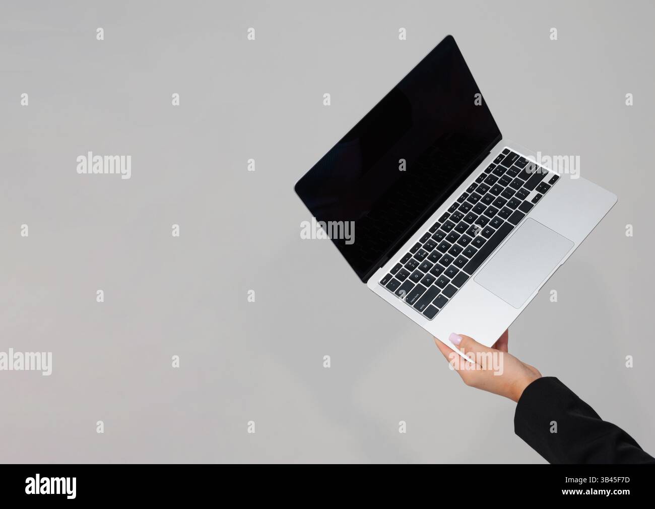 Laptop-Computer mit schwarzem Bildschirm auf grauem Hintergrund, minimales technisches Business-Konzept. Stockfoto