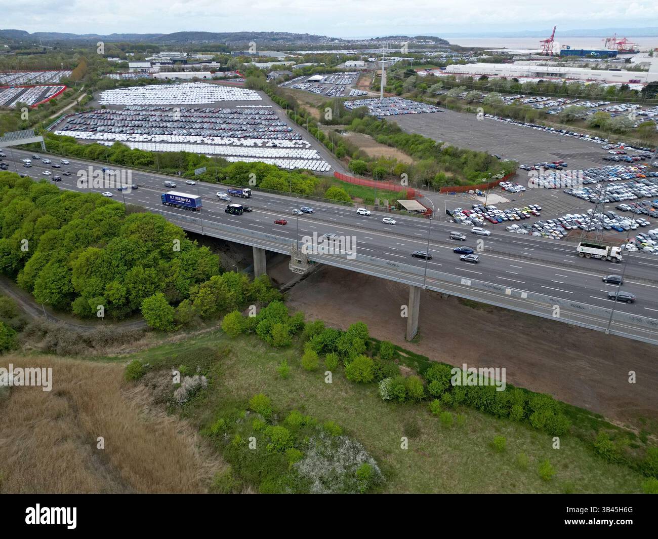 Drohnenansicht der Autobahn M5 auf dem Avonmouth Flyover und Portbury Docks New Car Storage Area, Bristol, Großbritannien, April 2025 Stockfoto