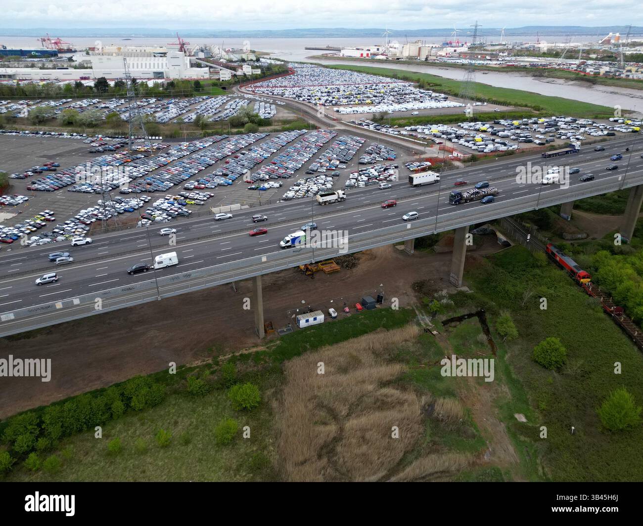 Drohnenansicht der Autobahn M5 auf dem Avonmouth Flyover und Portbury Docks New Car Storage Area, Bristol, Großbritannien, April 2025 Stockfoto