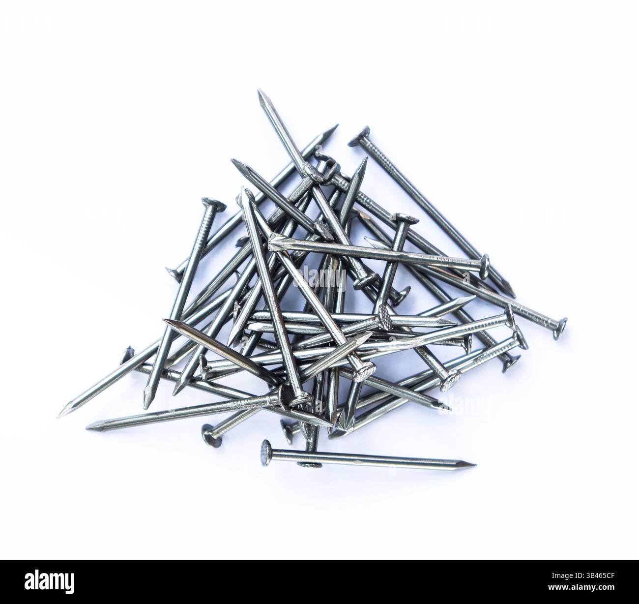 Nahaufnahme mit einem Haufen Metallnägel mit glänzenden Oberflächen vor weißem Hintergrund. Perfekt für Illustrationen oder Projekte im Zusammenhang mit Konstrukt Stockfoto