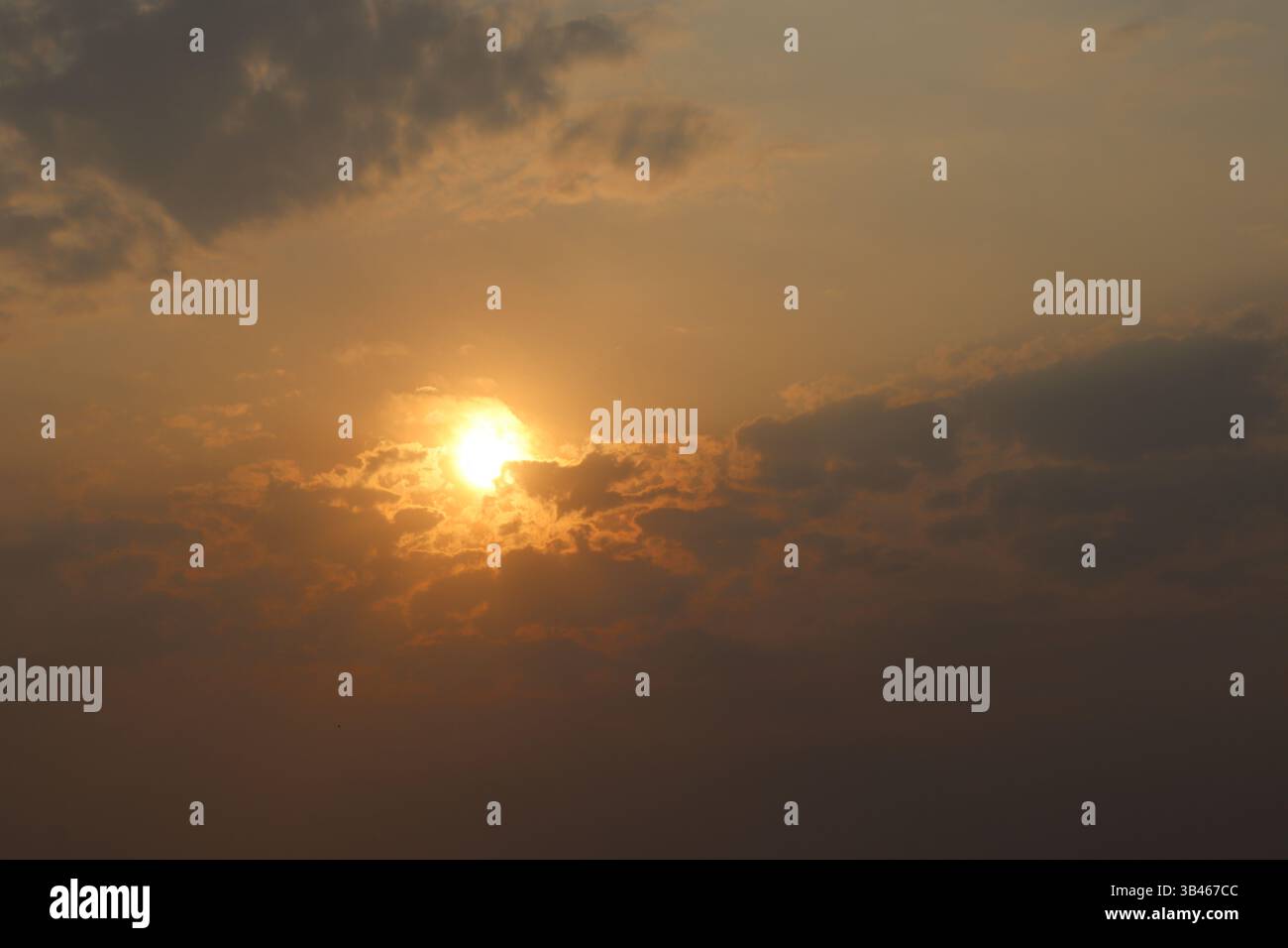 Faszinierende Landschaft des Abendhimmels mit heller Sonne, die durch die Wolken scheint und ein warmes, goldenes Licht wirft. Wolken verleihen der Szene Tiefe und Textur. Stockfoto
