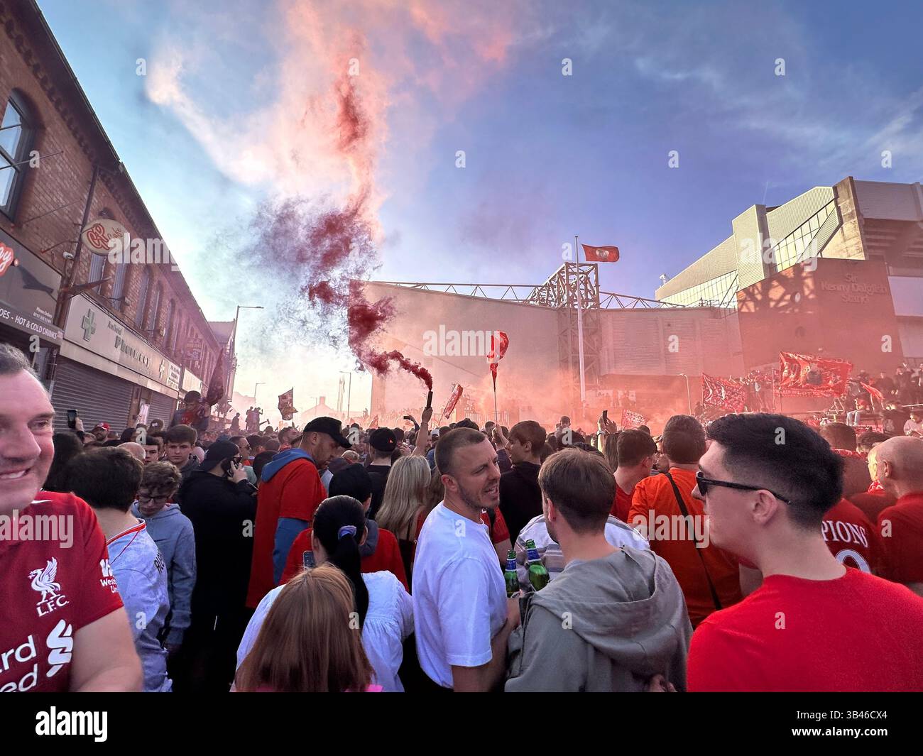 Fans feiern den Sieg in der Premier League in den Straßen vor Anfield mit roten Fahnen, 27. April 2025. - Smartphone-aufgenommenes Stockfoto