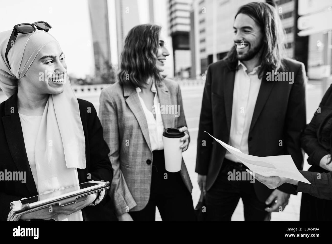 Multirassische Geschäftsleute, die außerhalb des Büros arbeiten, mit der Stadt im Hintergrund – Unternehmens- und Finanzkonzept – Schwarzweiß-Redaktion – Mai Stockfoto