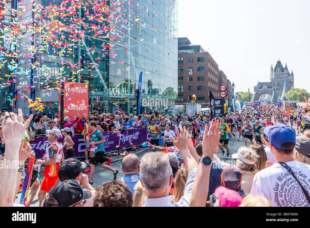 Lustige Läufer, die 2025 beim TCS London Marathon antreten, durchqueren Tower Hill, London, Großbritannien, nach Tower Bridge mit Unterstützern Stockfoto