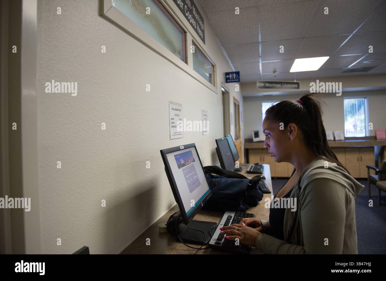 14. Juli 2015 - Sacramento - Davida Gomez beantragt Geburtsurkunden beim Sacramento County Clerk Recorder, Dienstag, 14. Juli 2015. Sie ist obdachlos und benötigt Geburtsurkunden für ihre drei Kinder, damit sie im August die Schule besuchen können. AB1733 ermöglicht es Obdachlosen, ohne eine Gebühr eine Bescheinigung über die Lebendgeburt zu erhalten, wenn sie ihren Status als Obdachloser oder obdachloses Kind nachweisen können. (Kreditbild: © Lezlie Sterling/Sacramento Bee Via ZUMA Press) Stockfoto
