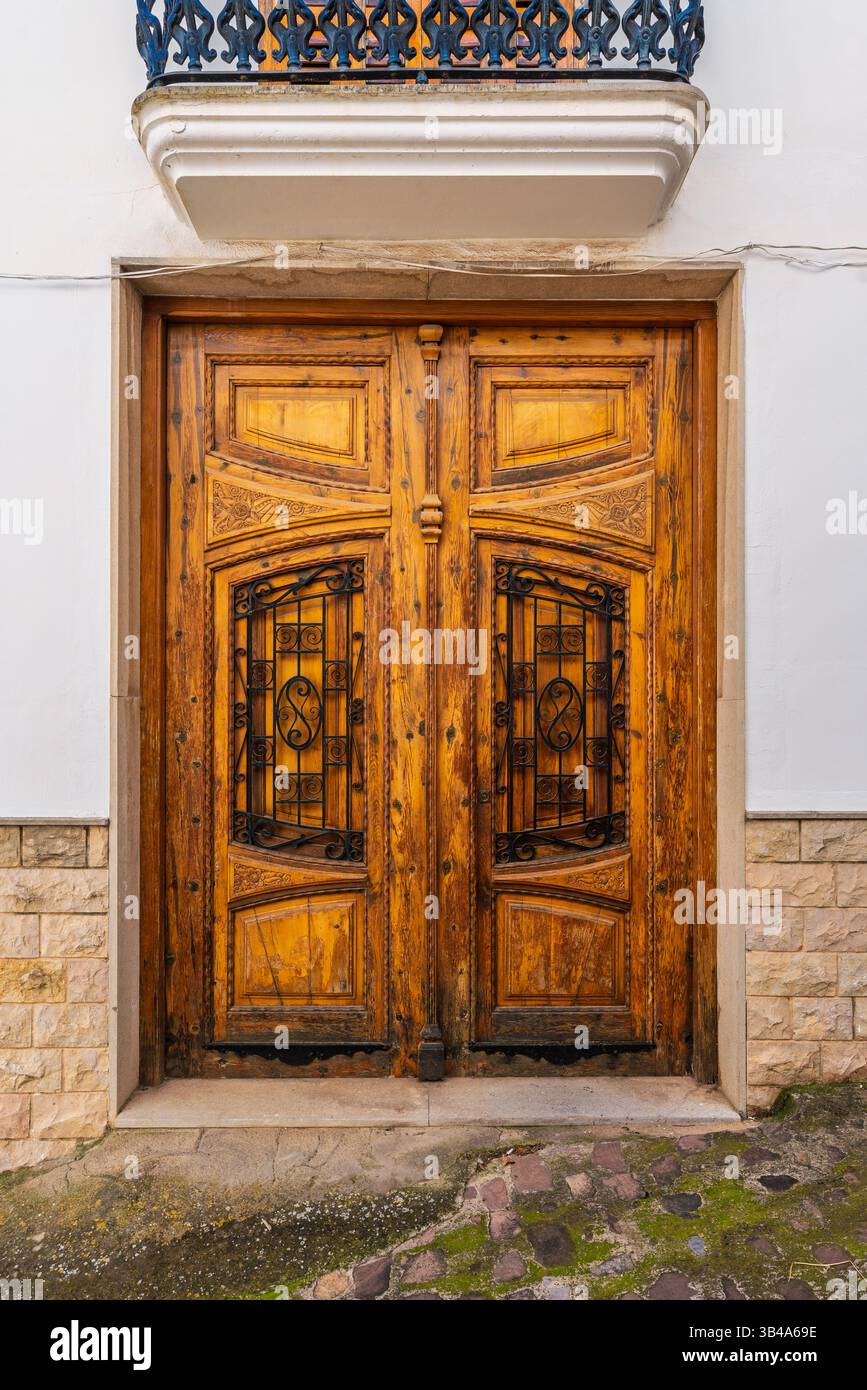 Eine wunderschön gefertigte Holztür mit kunstvollen schmiedeeisernen Paneelen in der historischen Stadt Segorbe, Spanien, die traditionelles spanisches Design zeigt Stockfoto