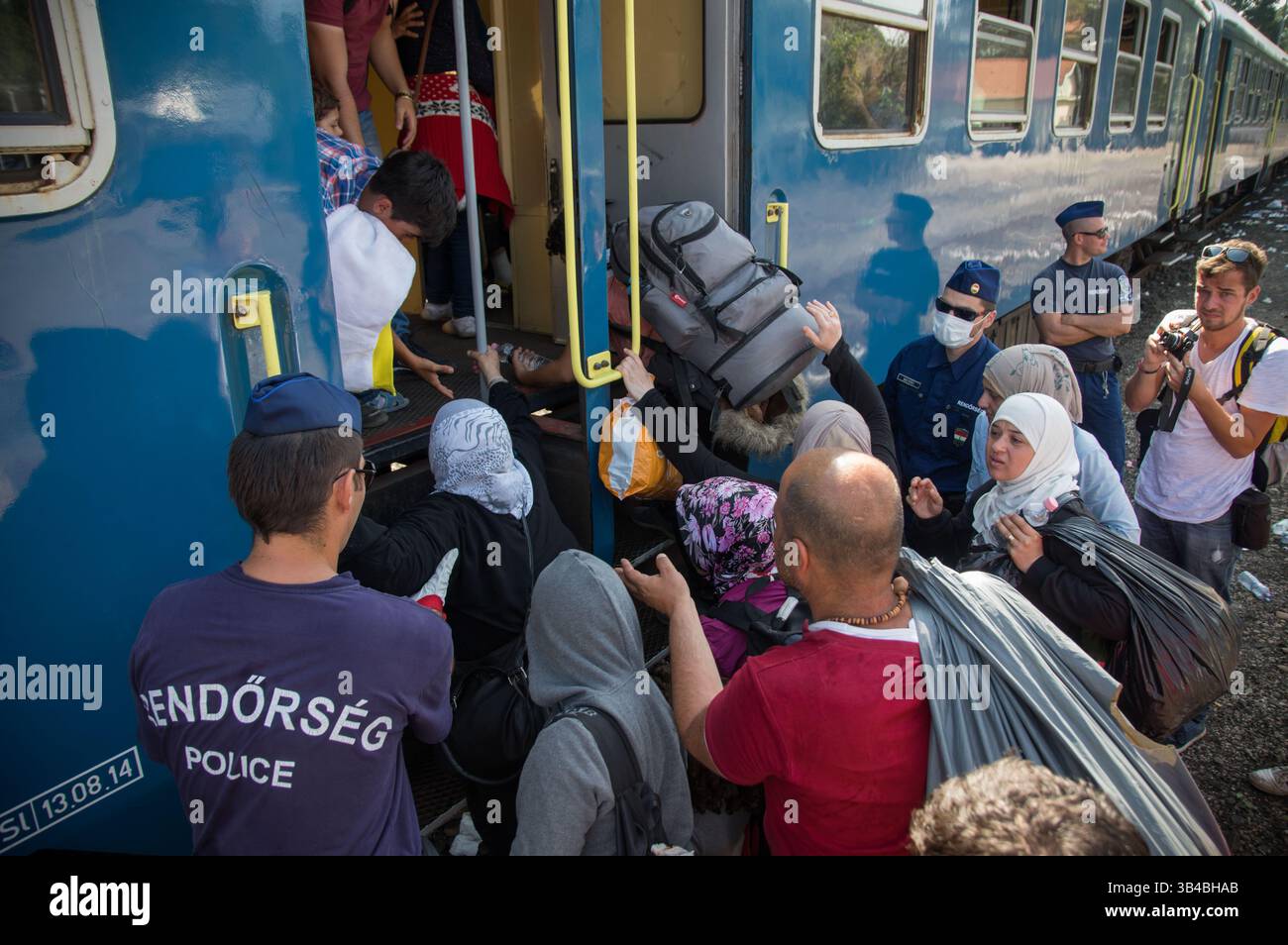 14. September 2015: Flüchtlinge sahen, wie sie in den Zug stürzten, der sie in Richtung Österreich bringen wird. - Die ungarischen Behörden waren auf Züge angewiesen, um Flüchtlinge von der Ungarisch-serbischen Grenze nach Österreich zu transportieren, da sie die Grenze zu Serbien innerhalb der nächsten Stunden schließen wollten. 14. September 2015. (Kreditbild: © Geovien so via ZUMA Wire) Stockfoto