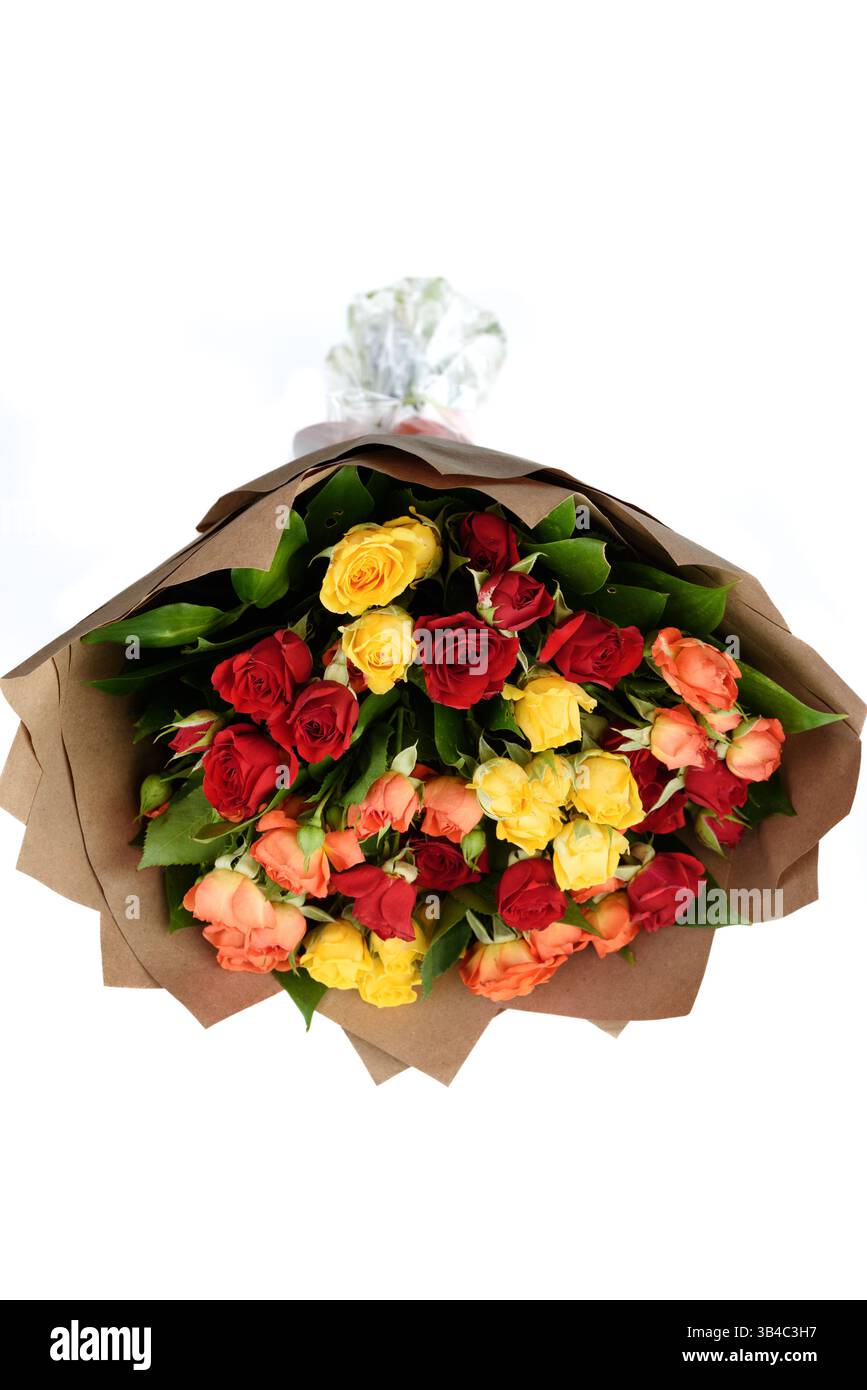 Ein Strauß mehrfarbiger Rosen, verpackt in braunem dickem Papier auf weißem Hintergrund. Kopierbereich. Stockfoto
