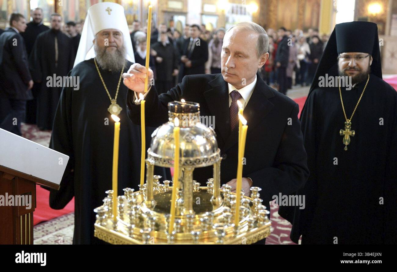 15. Oktober 2015 - Astana, Kasachstan - der russische Präsident Wladimir Putin zündet eine Kerze an, während er die Himmelfahrt-Kathedrale während des Gipfels der Unabhängigen Staaten, ehemaliger Sowjetrepubliken, 15. Oktober 2015 in Astana, Kasachstan, besucht. Links ist der orthodoxe Metropolit Alexander von Astana und Kasachstan. (Bild: © Alexei Nikolsky/Planet Pix via ZUMA Wire) Stockfoto