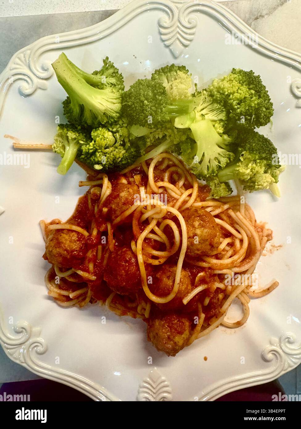 Abendessen mit Spaghetti und Fleischbällchen mit Brokkoli auf einem weißen Teller. Nahaufnahme. Stockfoto
