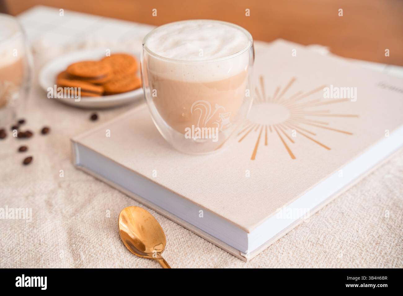 Charming Coffee still Life – Tasse Espresso auf Kunstbuch mit Cookies Stockfoto