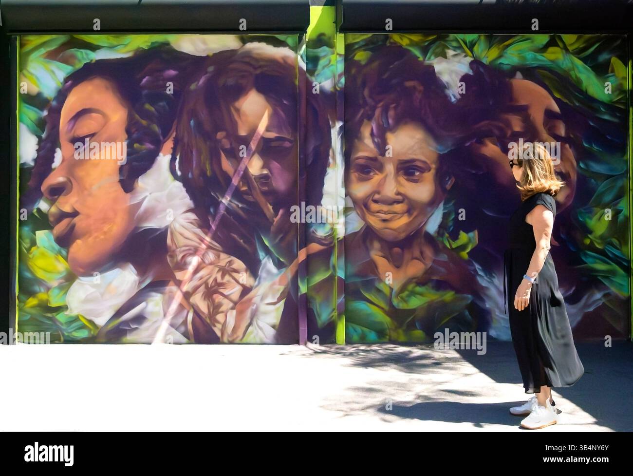 Frau schaut sich Wandkunst in Wynwood Walls, Miami, Florida, USA an Stockfoto