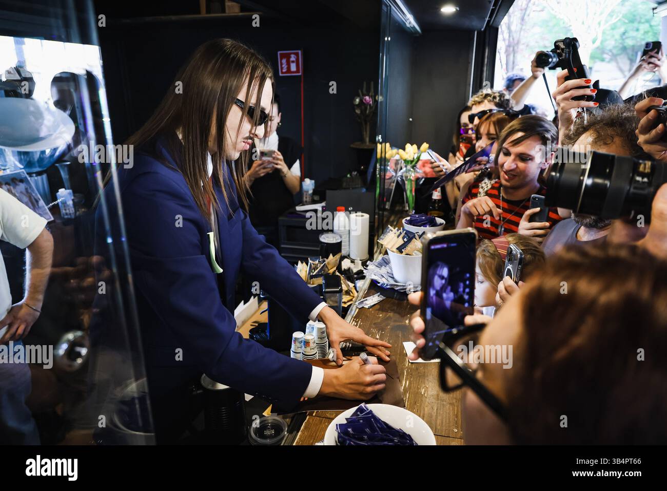 Mailand, Italien. April 2025 30. Tommy Cash (Tomas Tammemets) trifft Fans und vertreibt Kaffee, um seinen Song Espresso Macchiato für den Eurovision Song Contest 2025 am Zeitungsstand auf der Piazza Morbegno zu präsentieren. Quelle: SOPA Images Limited/Alamy Live News Stockfoto