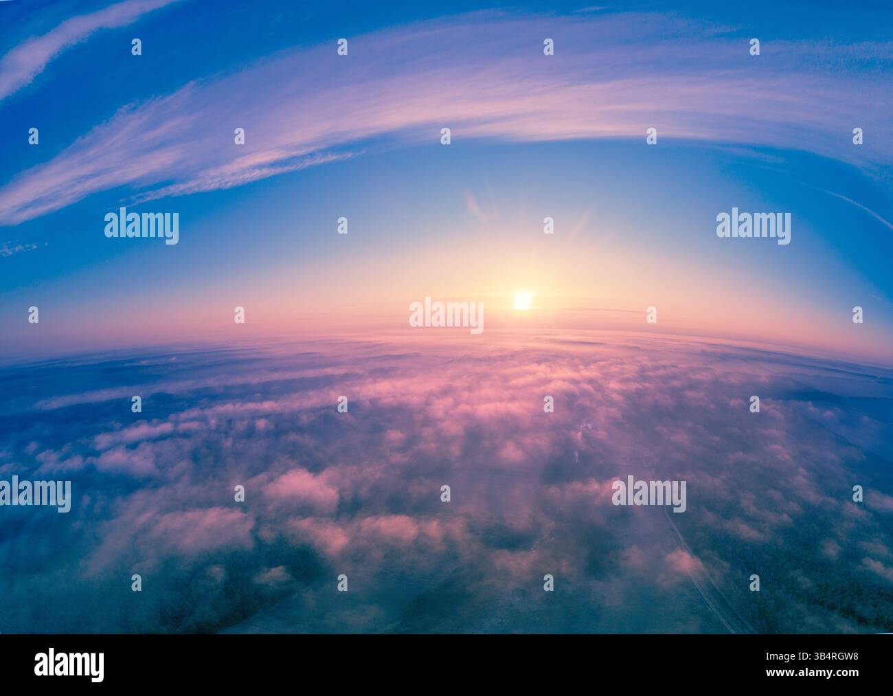 Erstaunlich früh nebeliger Morgen. Sonnenaufgang über den Wolken. Landschaft am Morgen mit einem wunderschönen Himmel Stockfoto