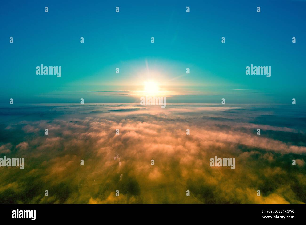 Erstaunlich früh nebeliger Morgen, Sonnenaufgang über einem nebeligen Feld. Ländliche Umgebung am Morgen. Draufsicht über dem Nebel Stockfoto