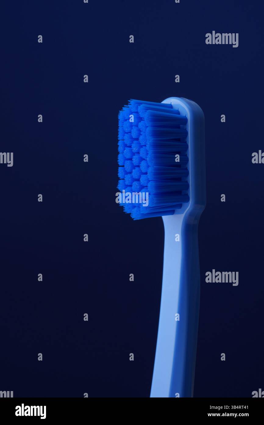 Nahaufnahme einer blauen Plastikzahnbürste auf blauem Hintergrund. Zahnheilkunde. Stockfoto